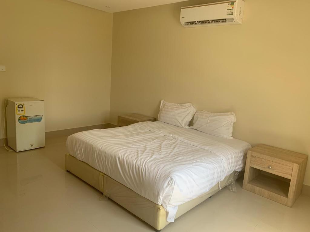 a bedroom with a white bed and a air conditioner at Mayyon Airport 101 in Riyadh