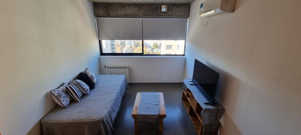 ein Wohnzimmer mit einem Sofa und einem Flachbild-TV in der Unterkunft Departamento en el centro de Neuquén Capital in Neuquén