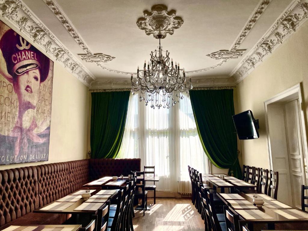 a dining room with tables and chairs and a chandelier at Upper Room Hotel Kurfürstendamm in Berlin