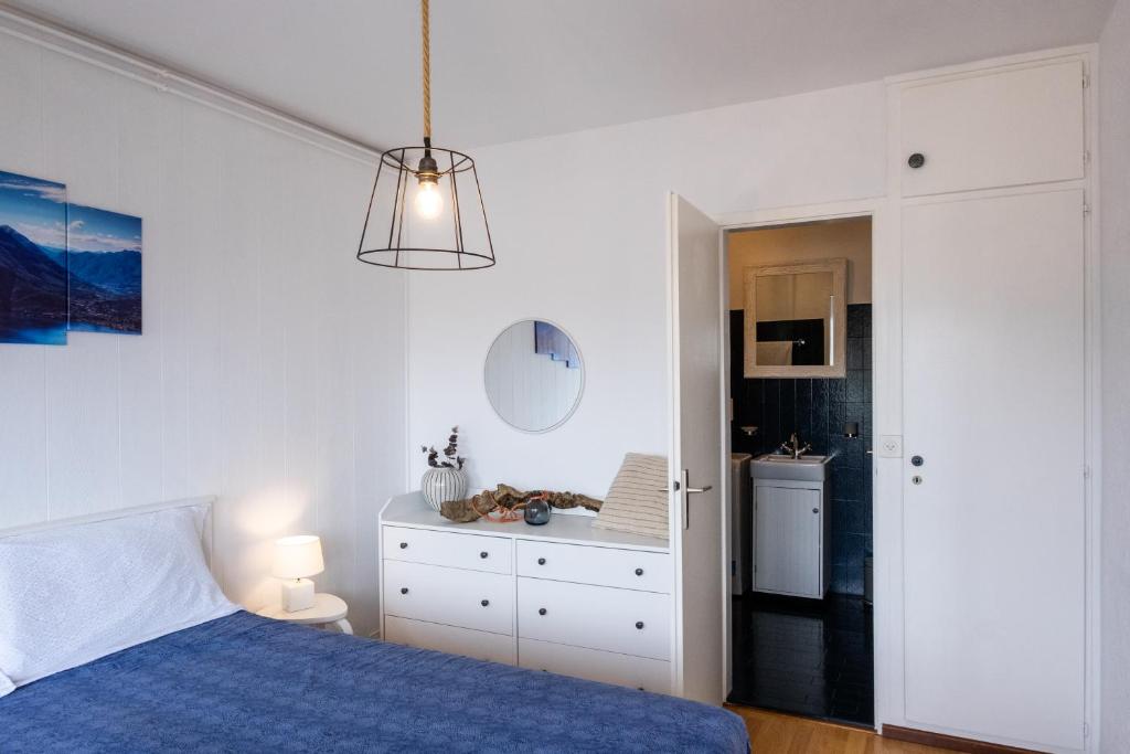 a bedroom with a blue bed and a kitchen at Lugano Boat Apartment in Lugano