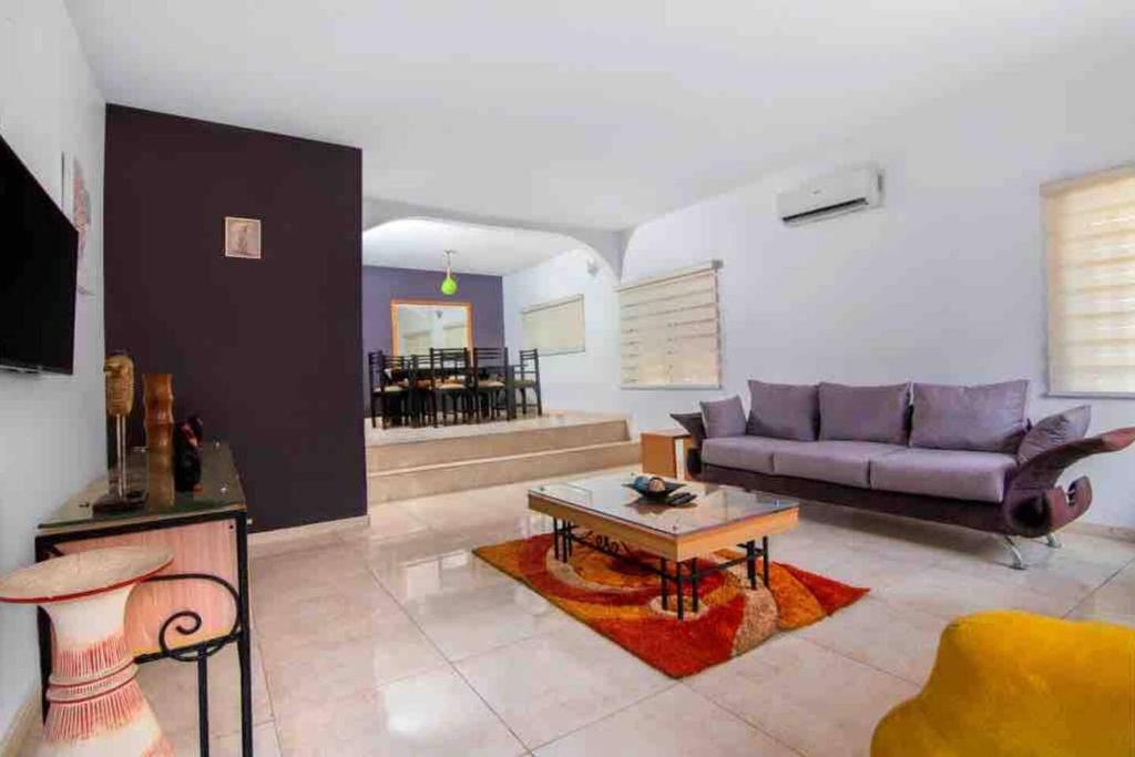 ein Wohnzimmer mit einem Sofa und einem Tisch in der Unterkunft Daffodil Suite in Lagos
