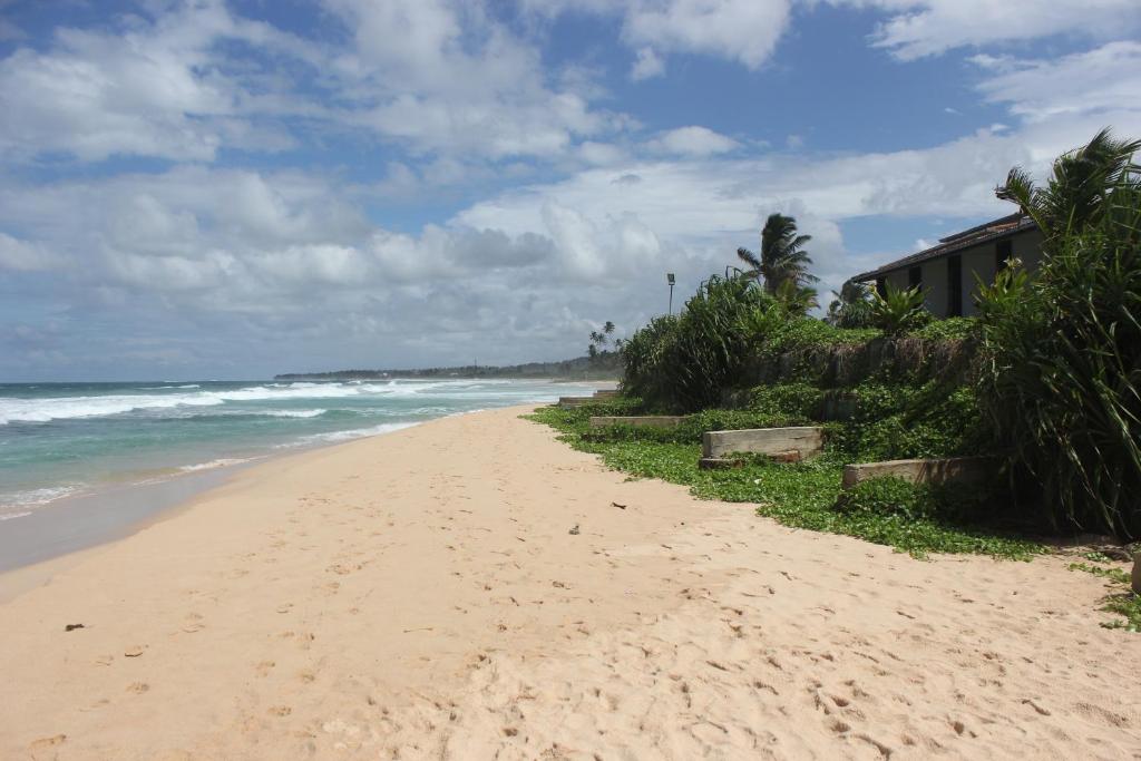 a sandy beach with the ocean in the background at The Beach Cabanas Retreat & Spa in Koggala