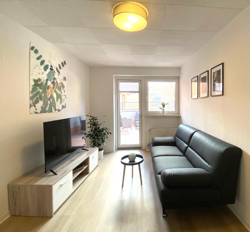 sala de estar con sofá y TV de pantalla plana en Exklusive Monteur-Unterkünfte Apartments, Balkon, Grill, Smart-TV, NETFLIX, Küche, en Aschersleben