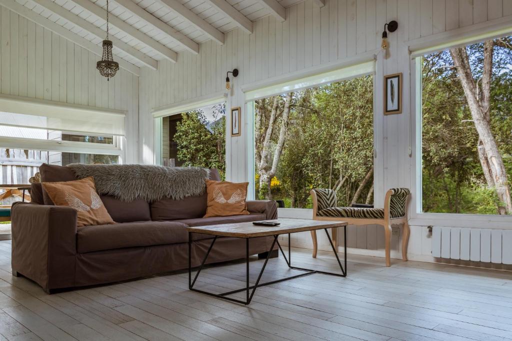 uma sala de estar com um sofá e uma mesa em BOG Nórdica 2 em Villa La Angostura