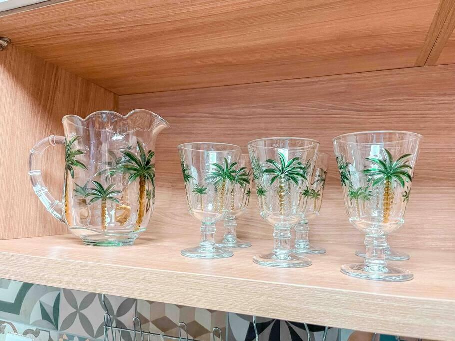 quatro copos de vinho de vidro com palmeiras numa prateleira em Apto próximo ao Shopping Boulevard em Belém