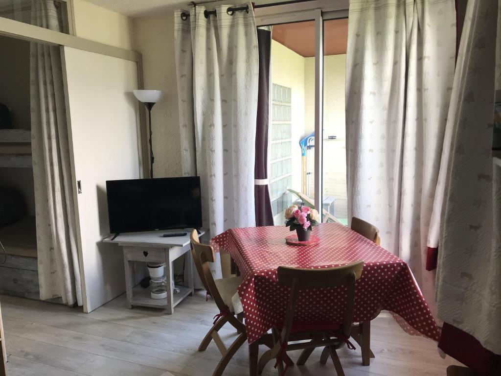 Chaleureux Logement - 4 Couchages في Uvernet: غرفة طعام مع طاولة حمراء وكراسي