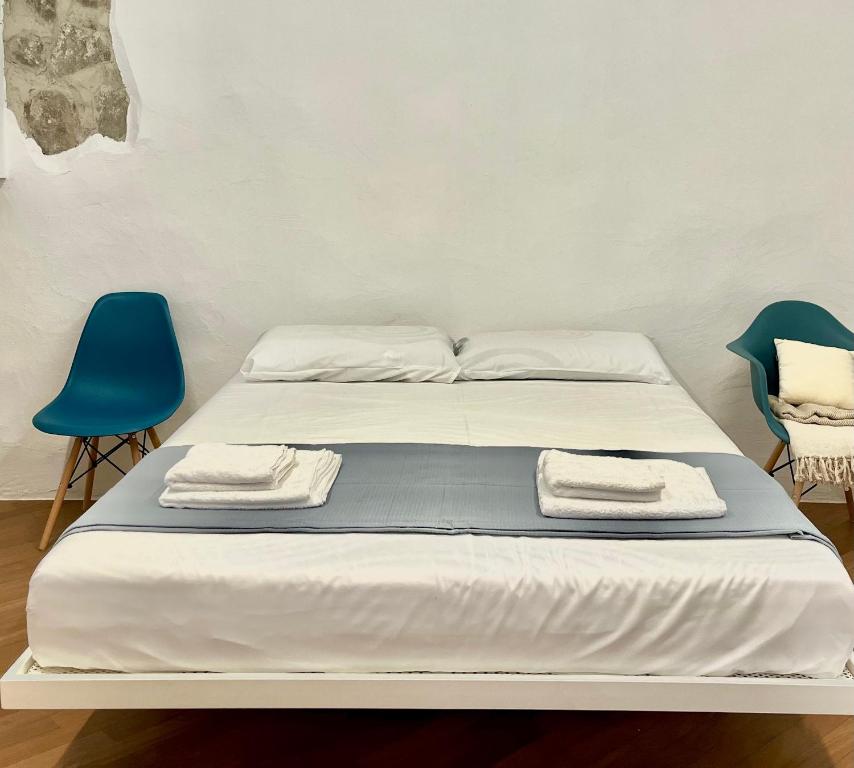 a bed with two chairs and two towels on it at Streiter Rooms in Bolzano