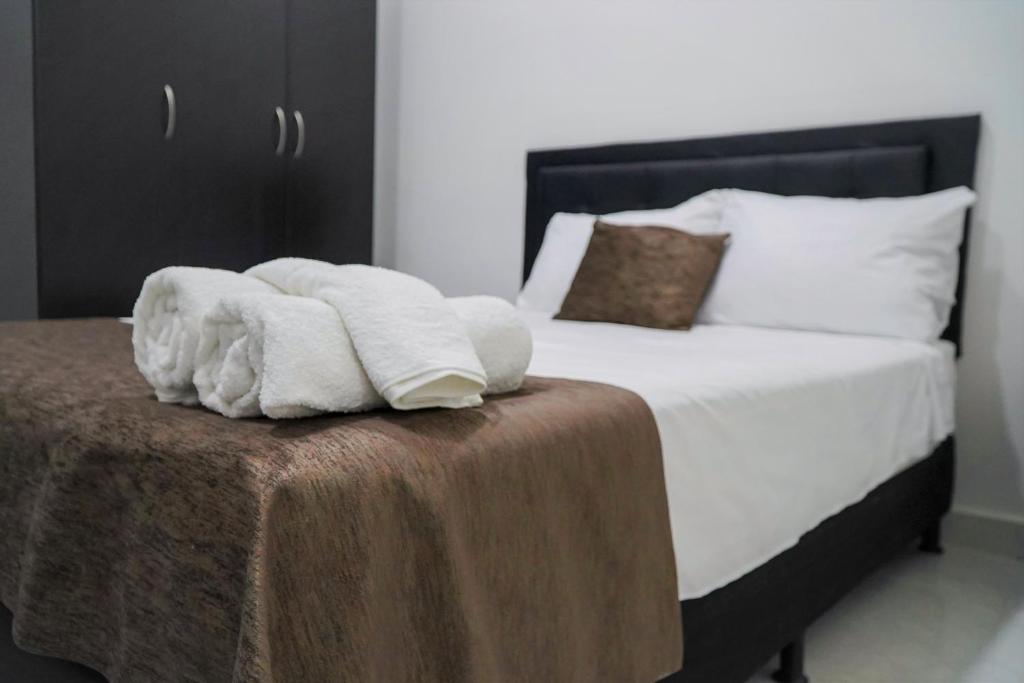 麥德林的住宿－Apartamentos, Colores del Estadio - Laureles.，一间卧室配有一张带毛巾的桌子。