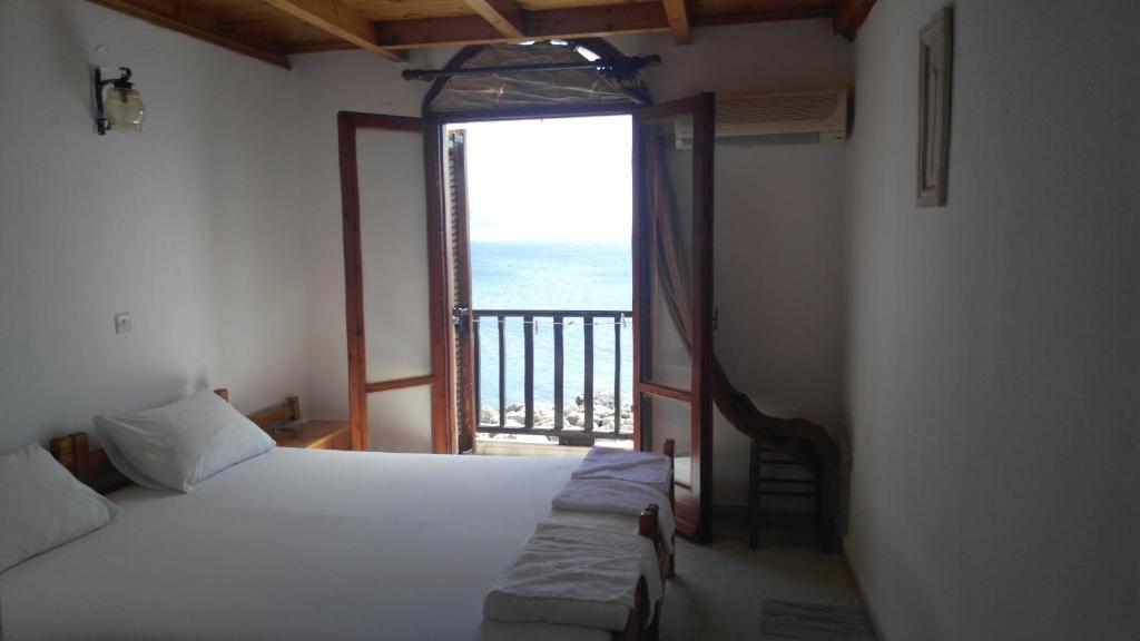 a bedroom with a bed and a large window at Spamandos Rooms in Palaiochora