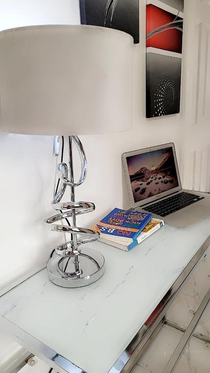 a white counter with a laptop and books on it at Mlandege apartment in Ngambo