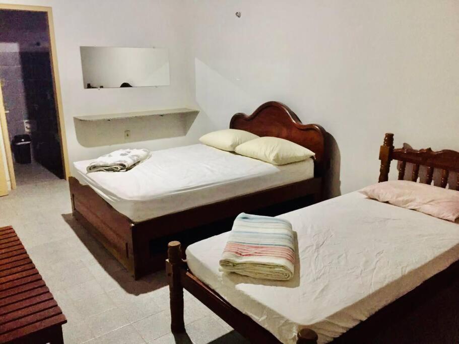 a bedroom with two beds and a mirror on the wall at Casa Brisas in Luis Correia