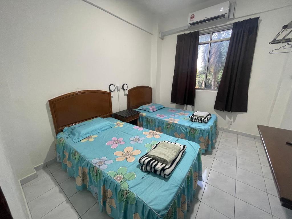 a room with two beds in a room at D Nish Homestay in Tawau