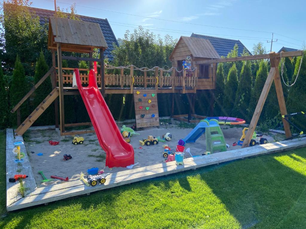 a play yard with a playground with a slide at Miło Cię widzieć in Łeba