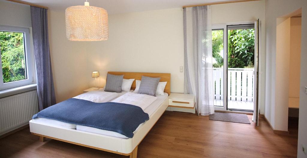 a bedroom with a bed with a blue blanket at Apartmenthaus Oberndorf 