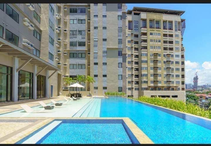 a large swimming pool in front of a building at Nice location in the persimmon condo in Cebu City