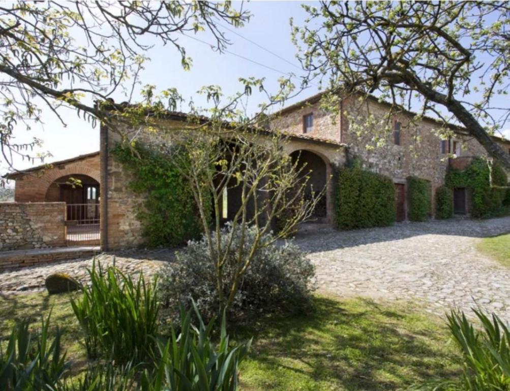 an old stone house with a garden in front of it at PodereVicoBasso Siena in Siena