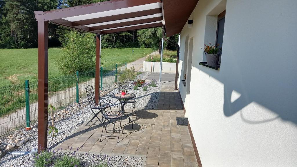 eine Terrasse mit einem Tisch und Stühlen unter einem Sonnenschirm in der Unterkunft Spa Apartmán Kováčová in Kováčová