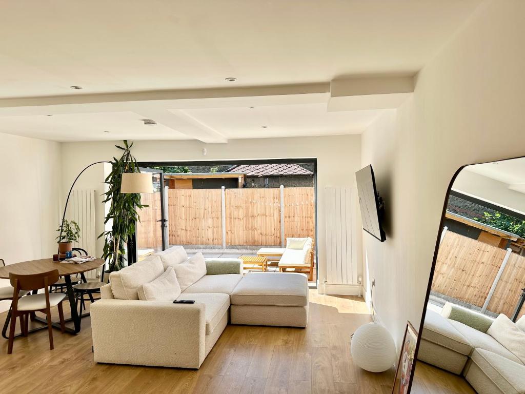 ein Wohnzimmer mit einem weißen Sofa und einem Tisch in der Unterkunft Luxurious, spacious, sunny & modern apartment in London