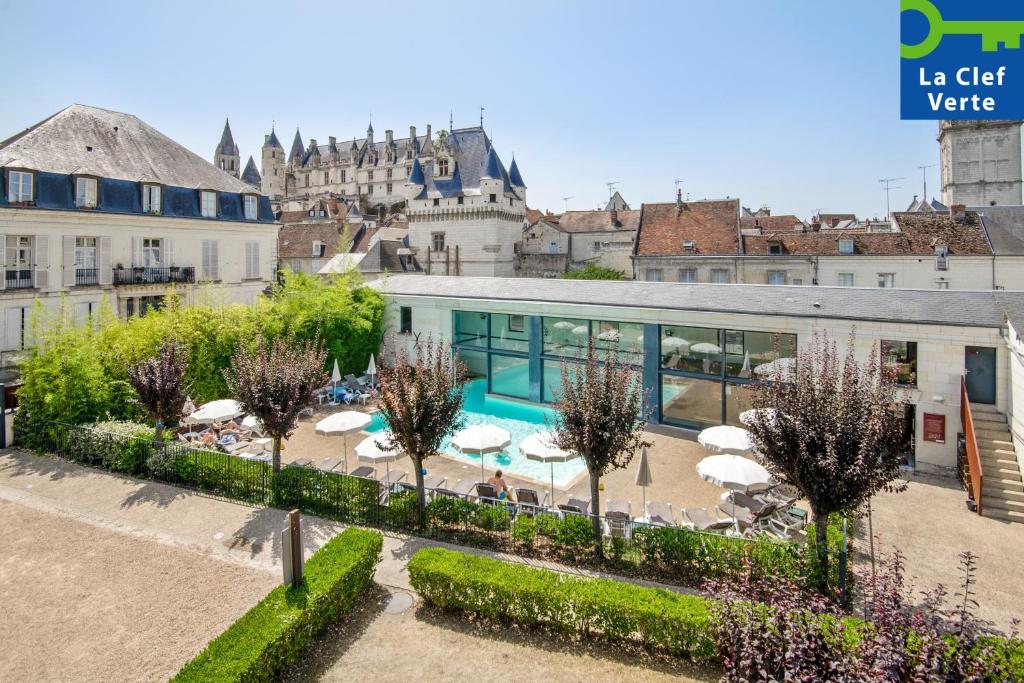 - une vue sur un bâtiment avec une piscine et des parasols dans l'établissement Pierre & Vacances Le Moulin des Cordeliers, à Loches