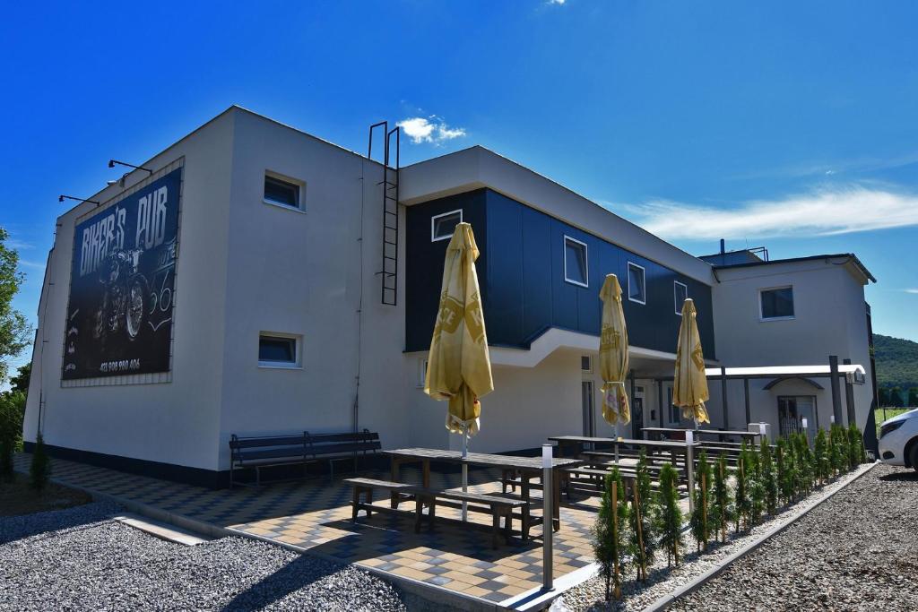 ein Gebäude mit Tischen und Sonnenschirmen davor in der Unterkunft Chata na Zemplinskej Širave až pre 40 ľudí in Kaluža