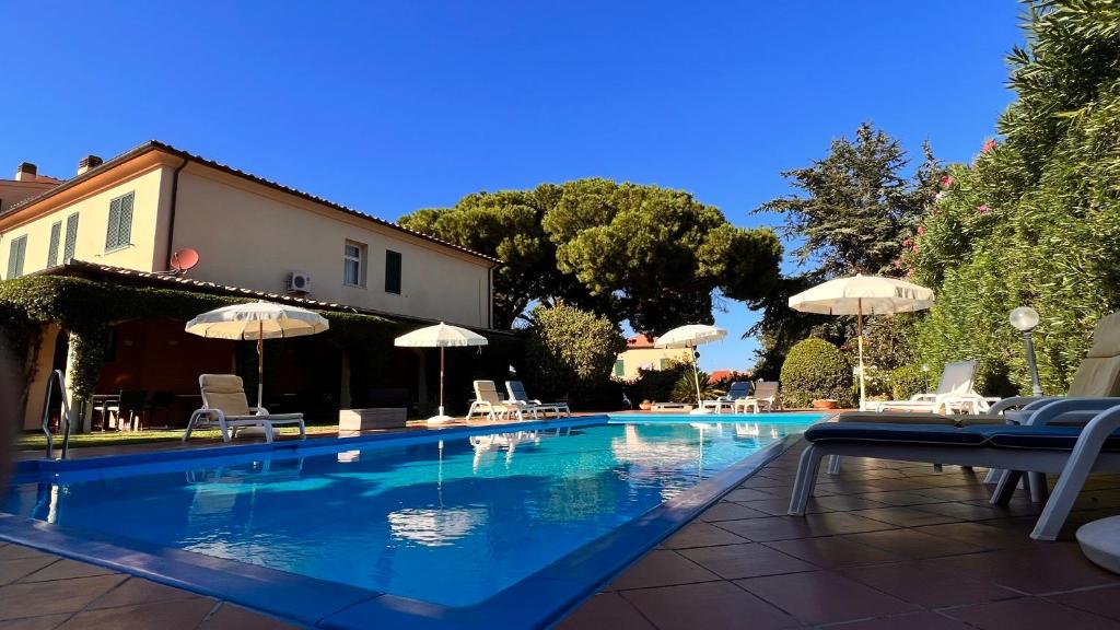 einen Pool mit Stühlen und Sonnenschirmen im Hof in der Unterkunft Residence Il Gabbiano Azzurro in Marciana Marina