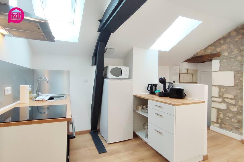 a kitchen with white cabinets and a black pipe at Le Cypri&#39;Deux by iZiLi *Confort*Calme* in Poitiers