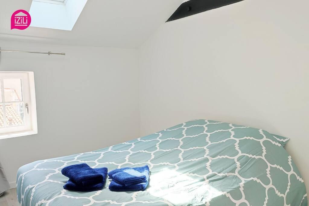 a bedroom with a bed with blue pillows on it at Le Cypri&#39;Deux by iZiLi *Confort*Calme* in Poitiers