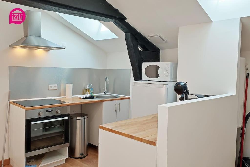 a small kitchen with a sink and a stove at Le Cypri&#39;Deux by iZiLi *Confort*Calme* in Poitiers