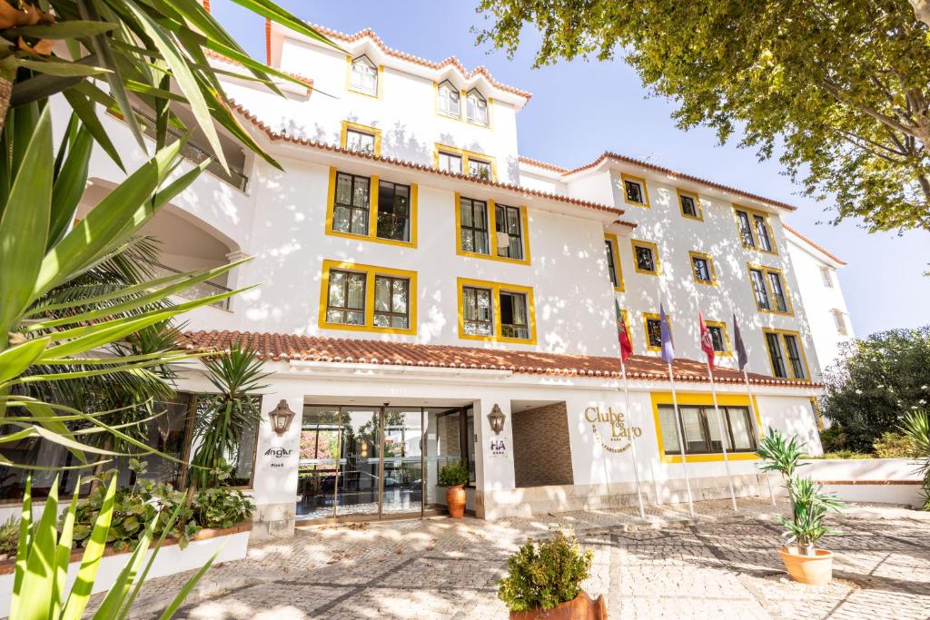 a large white building with yellow windows at Clube do Lago Hotel in Estoril