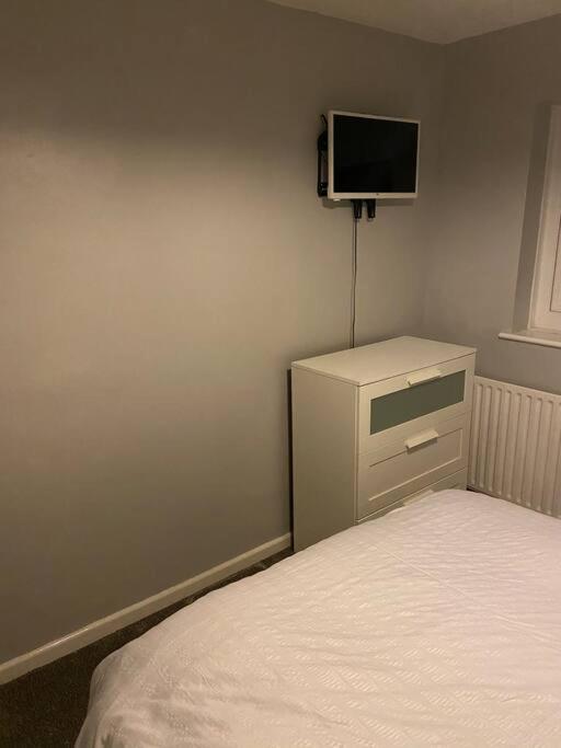 a bedroom with a bed and a tv on the wall at Cosy 1 Bed Home @Stevenage in Shephall