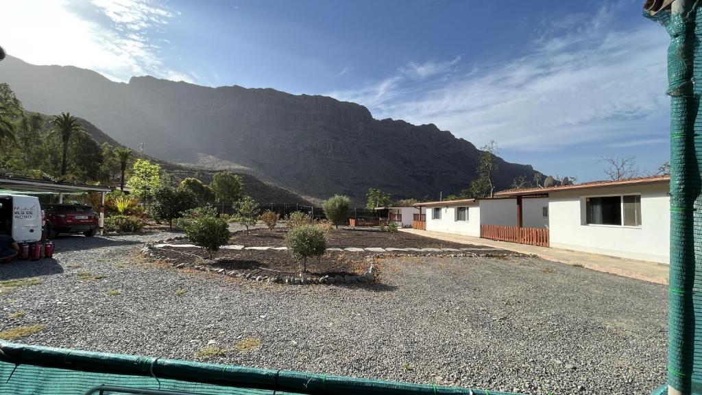einen Hof mit einem Haus und einem Berg im Hintergrund in der Unterkunft Renovated Tiny House in the Country near Fataga in Artedara