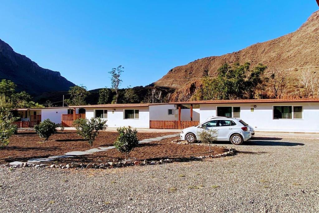 Artedara的住宿－Cosy Apartment in the Mountains near Maspalomas，停在大楼前的汽车
