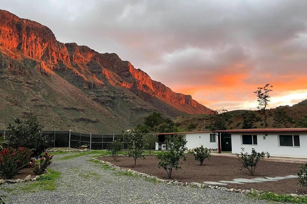 a house in front of a mountain with a sunset at 2 Bedroom Country House Near Fataga & Maspalomas in Artedara