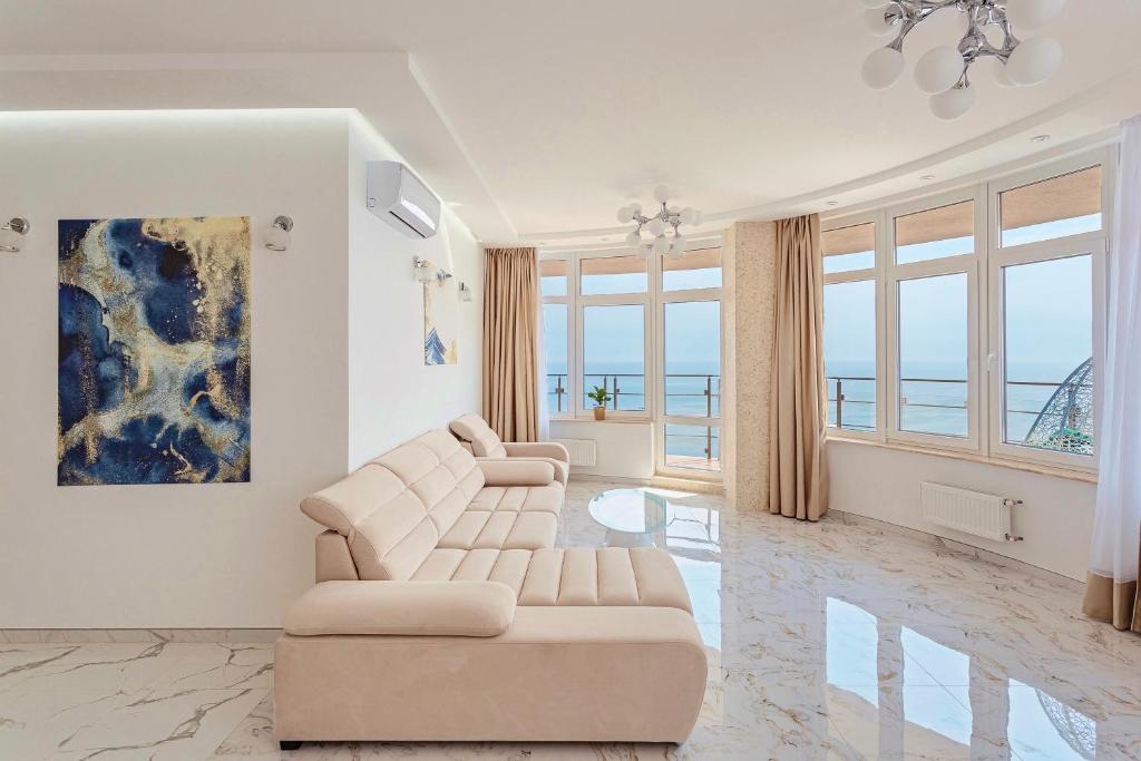 a living room with a couch and chairs and windows at Direct sea view in Odesa