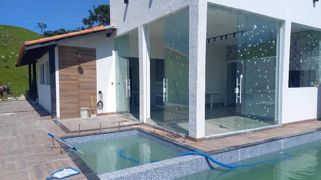 a house with a swimming pool in front of it at Casa de campo in Natividade da Serra