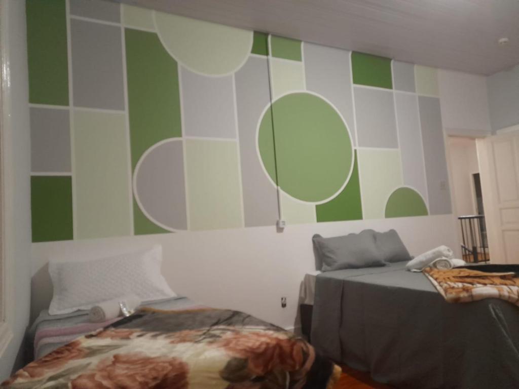 1 dormitorio con 1 cama y pared verde y blanca en Hotel Palace City Agudos en Agudos