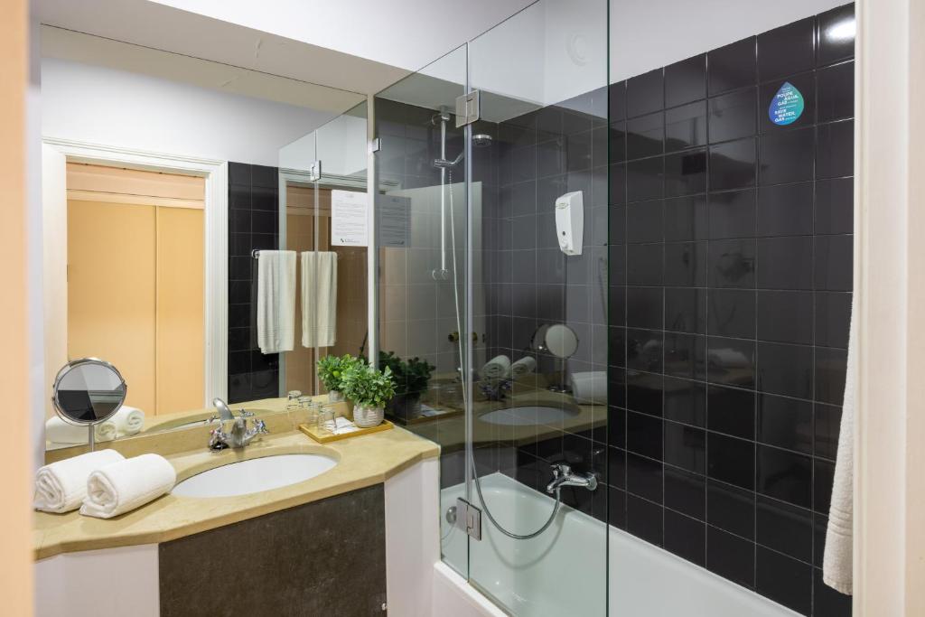 a bathroom with a sink and a glass shower at Clube do Lago Hotel in Estoril