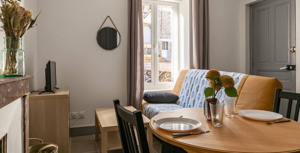 a living room with a table and a couch at Le Coeur Ardéchois in Vals-les-Bains