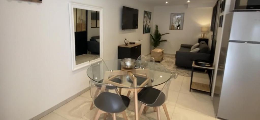 uma sala de estar com uma mesa de vidro e cadeiras em L'ATELIER em Bernardswiller