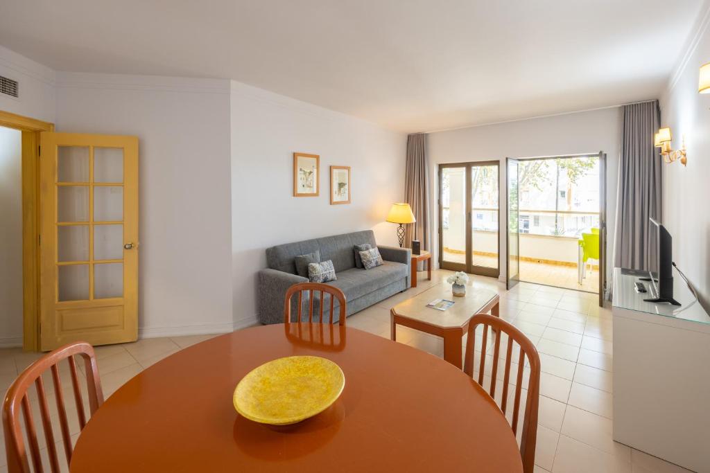 a living room with a table and chairs and a couch at Clube do Lago Hotel in Estoril