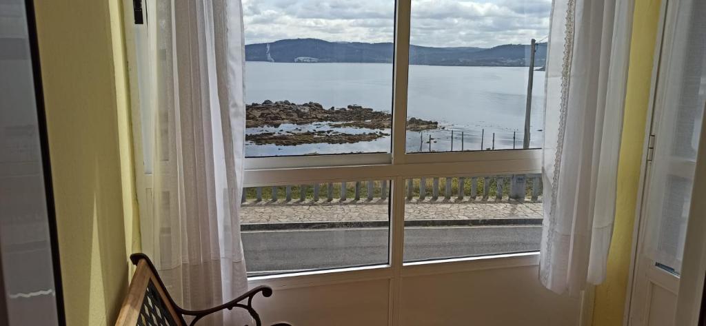 a room with a window with a view of the water at Apartamento Carmen en Muxía in Muxia
