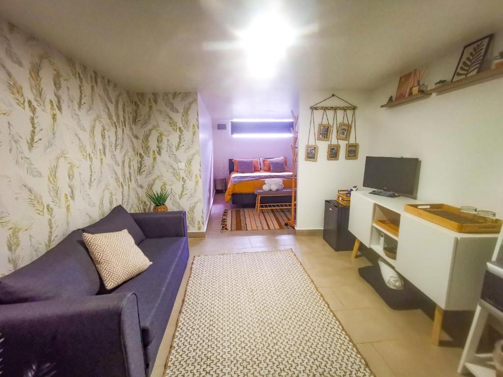 ein Wohnzimmer mit einem lila Sofa und ein Schlafzimmer in der Unterkunft Cantinho da Susana in Coimbra