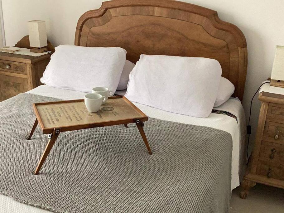 uma cama com uma mesa de madeira com uma bandeja em Los Lapachos em Paraná