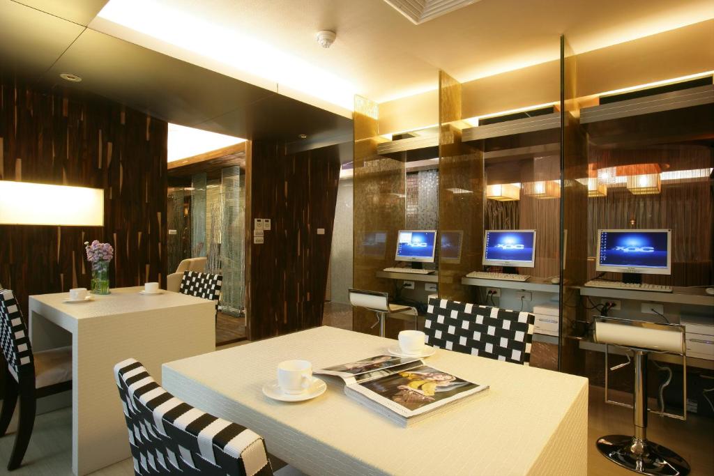 a restaurant with a table and chairs and two monitors at In One City Inn in Taichung