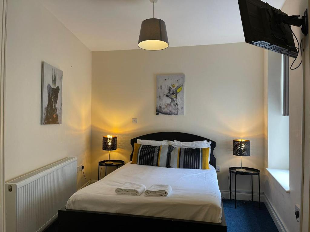 a bedroom with a white bed with two lamps at King's Cross Quiet Apartment in London