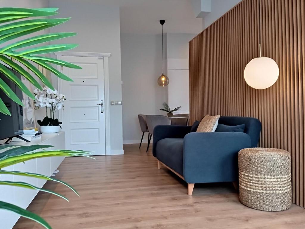 ein Wohnzimmer mit einem blauen Sofa und einem Tisch in der Unterkunft Príncipe Boutique apartments in Vigo