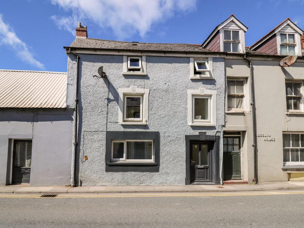 a blue and white building on the side of a street at Lane Cottage in Cardigan