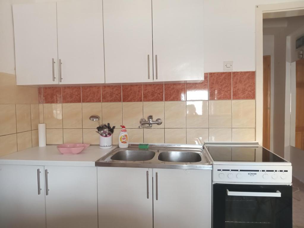 eine Küche mit weißen Schränken und einem Waschbecken in der Unterkunft Apartman Vojka in Višegrad