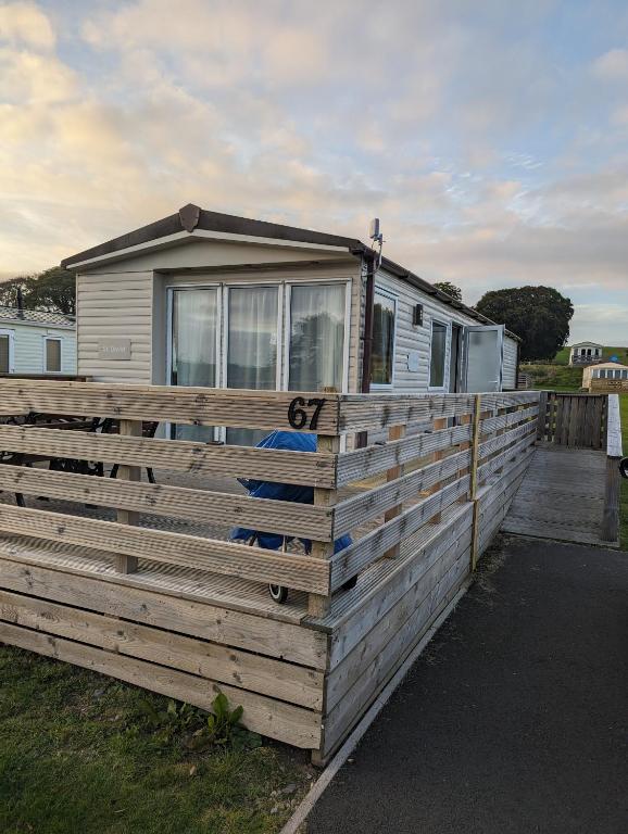 a large wooden fence around a mobile home at Loch's Heaven 67 in Kirkcowan