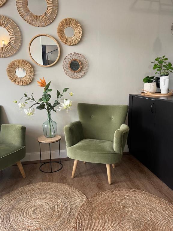 ein Wohnzimmer mit einem grünen Stuhl und einem Spiegel in der Unterkunft MAX Hotel Düsseldorf Self-Check-in in Düsseldorf